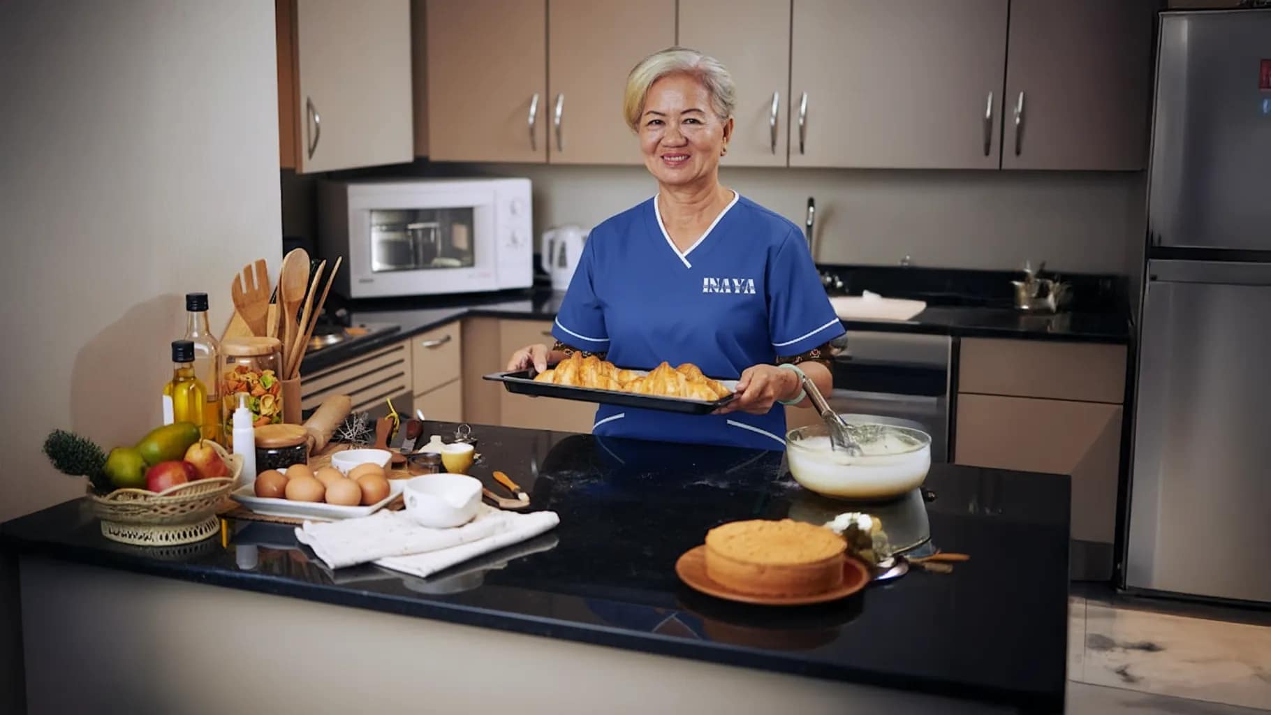 Maid in INAYA uniform washing dishes in Ajman